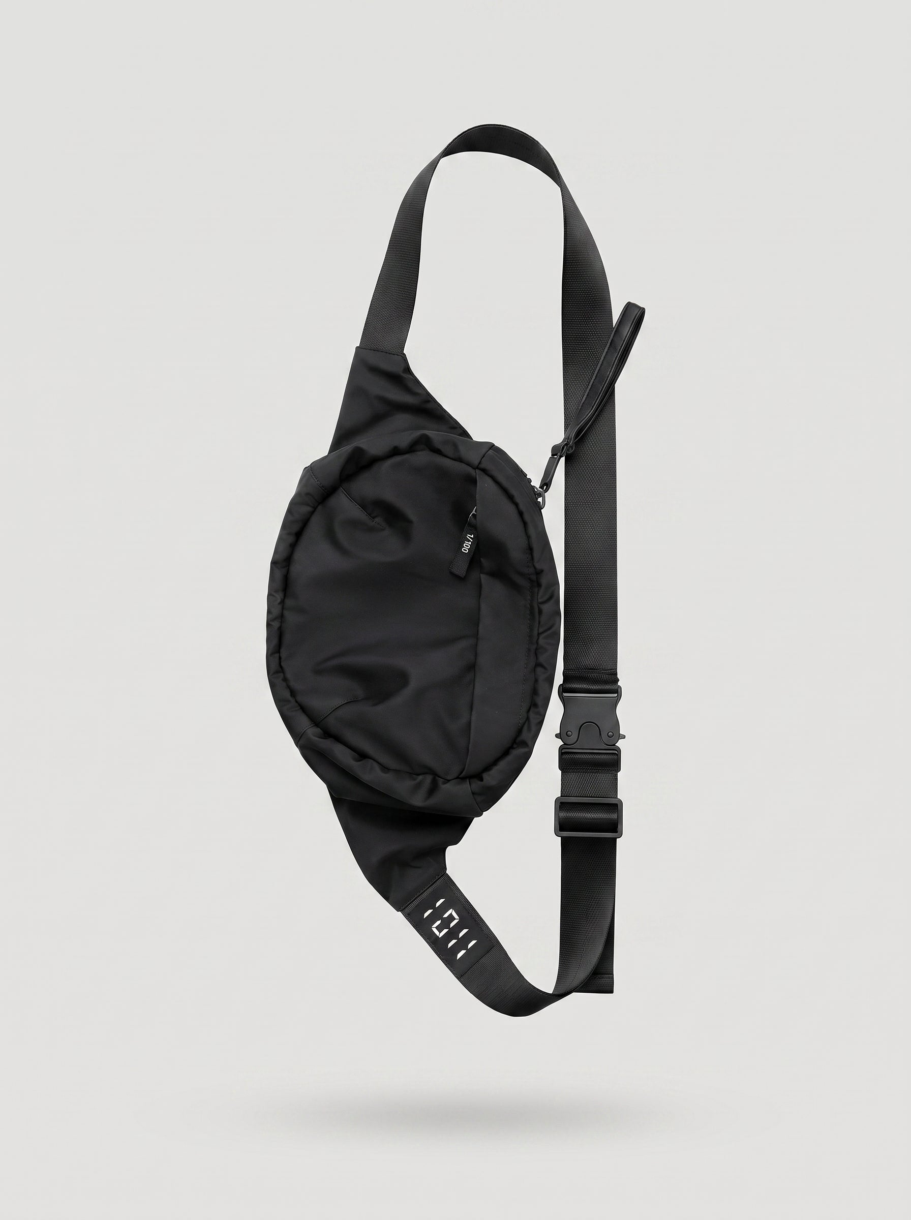Black waist bag with a strap on a light gray background