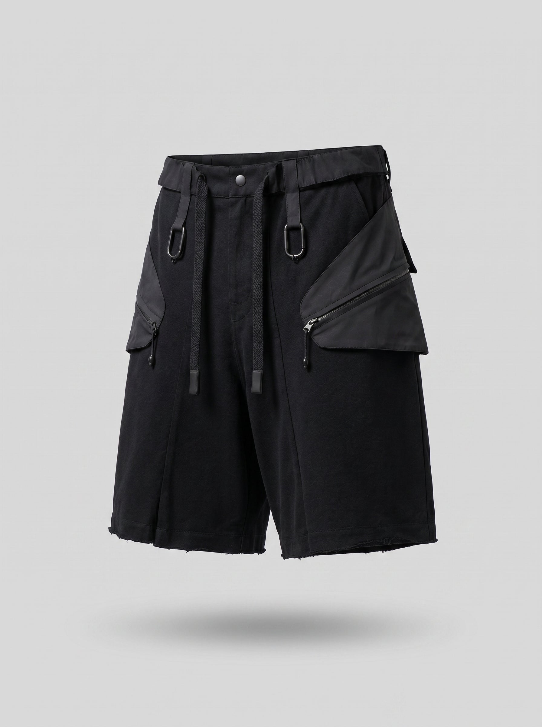 Black tactical shorts with multiple pockets and zippers on a gray background
