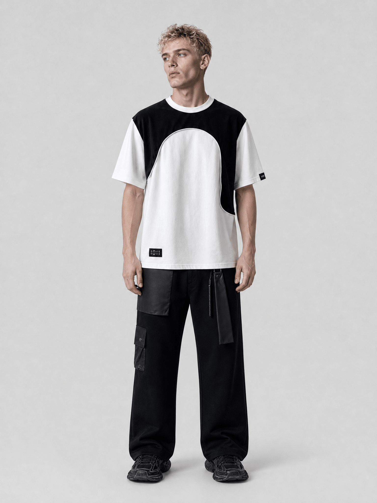 Person wearing a black and white outfit on a plain background