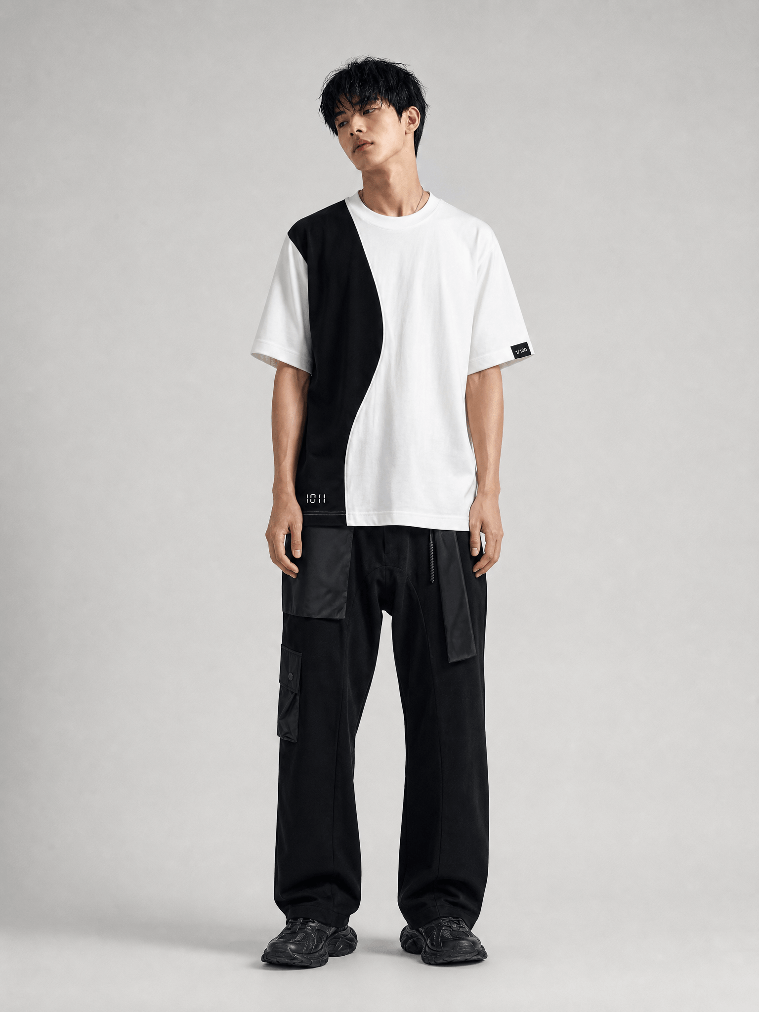 Person wearing a black and white outfit on a gray background